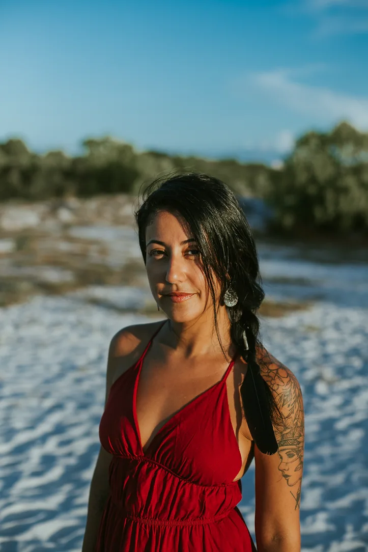 Alejandra deitada na areia branca com a rosa vermelha, introspecção da psique